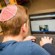 student with kippa on computer