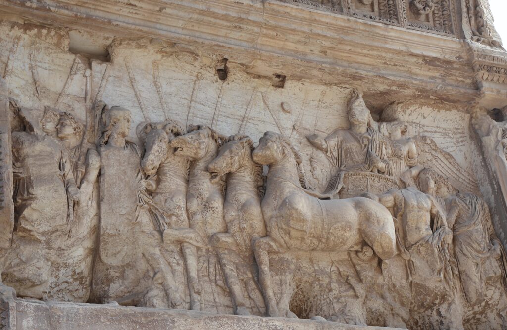 This relief from the Arch of Titus in Rome shows the emperor Titus in his chariot (right), behind his troops in the triumphal parade, accompanied by a (now headless) youth representing the citizens of Rome.
