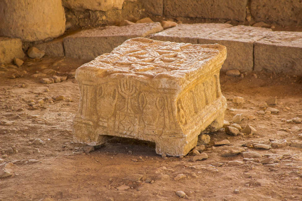 The earliest known stone table used for Torah reading ever excavated. One can easily see the high-quality depictions of holy items found in the Temple. Photo Credit: Shutterstock