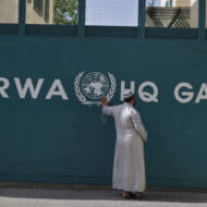 A man waits outside UNRWA headquarters in Gaza City. (FLASH90/Wissam Nassar)