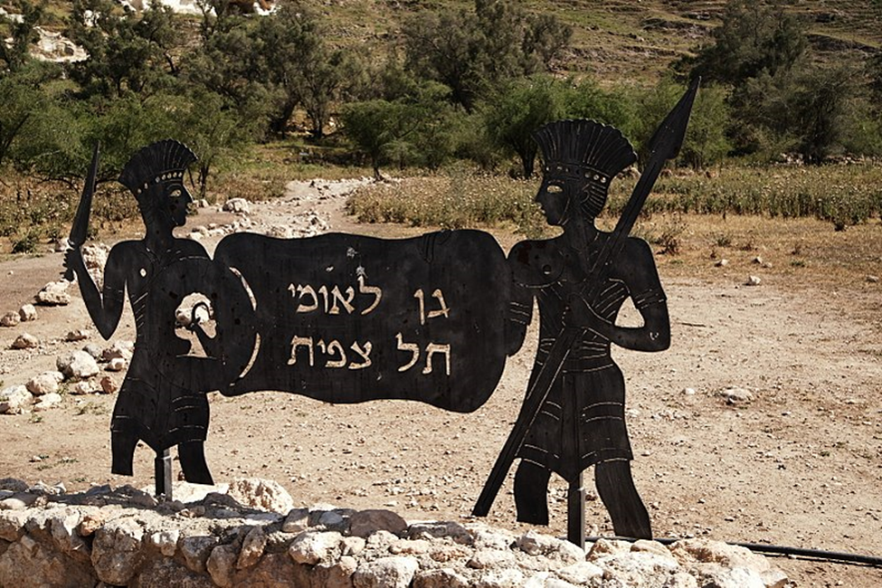 The sign, being held up by “Philistine soldiers” greets visitors to the site before they begin their exploration.  Photo Credit: Mboesch - Creative Commons Attribution-Share Alike 4.0 International